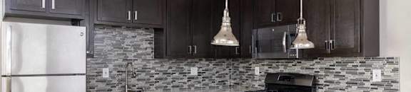 A kitchen with dark wood cabinets and a white counter.