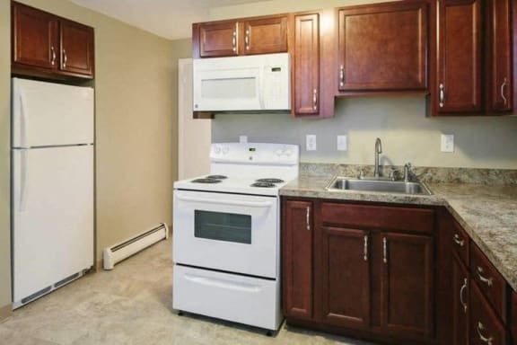 a kitchen with white appliances and wooden cabinets