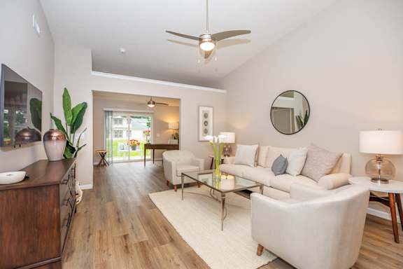 A modern living room with a white sofa and a glass coffee table.