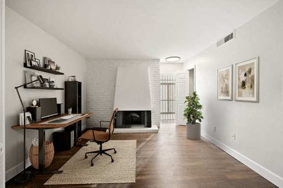 A room with a fireplace and a desk with a chair. at The Lex At Lowry, Denver, Colorado