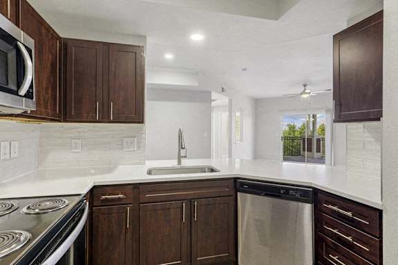 a kitchen with wooden cabinets and a sink and a dishwasher at The Legends at Eagle Mountain Lake, Fort Worth, 76179
