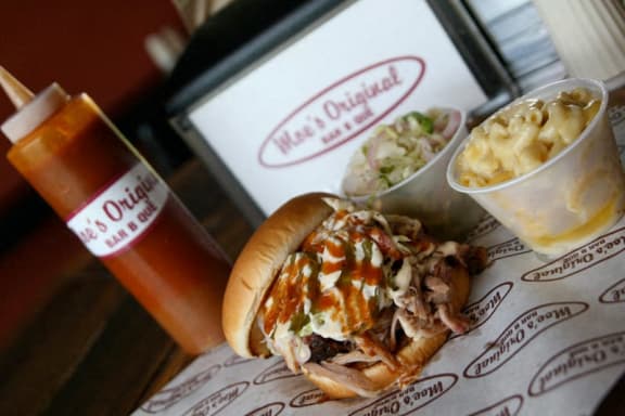 a hot dog with coleslaw and macaroni and cheese and a drink