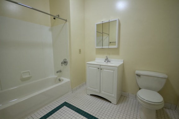 bathroom with white cabinet, white tile floors and off-white walls