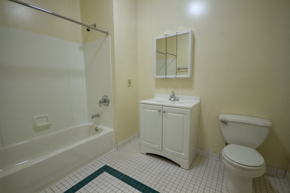 bathroom with white cabinet, white tile floor, and off white walls