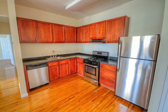 kitchen with hardwood floors, wooden cabinets and stainless steel appliances