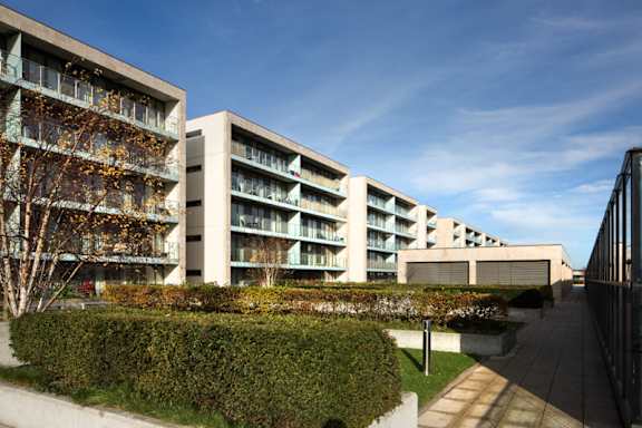 an apartment building with a courtyard and a blue sky