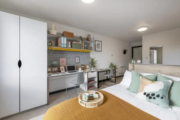 a bedroom with a bed and a desk with a computer