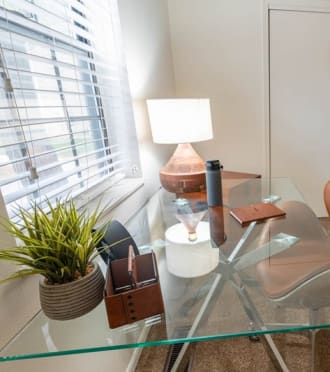 a glass desk in a room with a chair