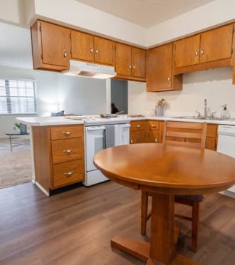 a kitchen with a wooden table in the middle