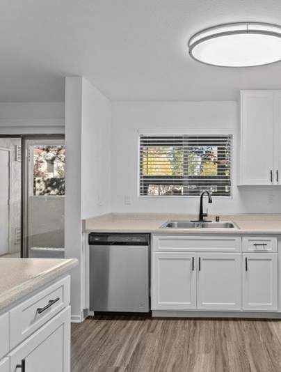 A modern kitchen with white appliances and cabinets.