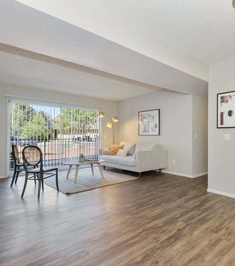 A living room with a white couch and a wooden floor.