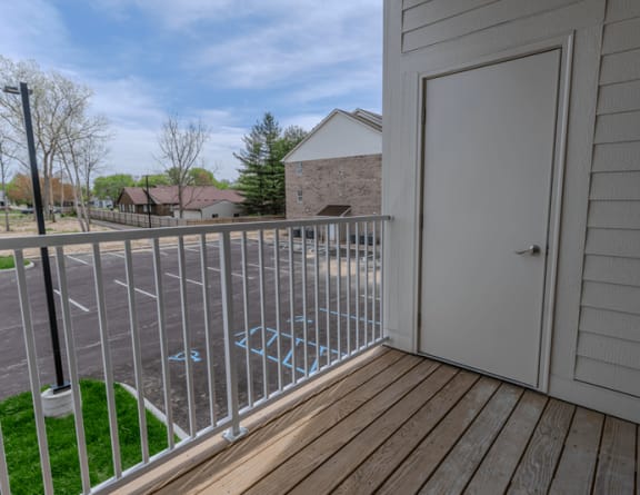 the balcony has a door to the yard and a view of the street