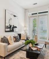 a living room with a fireplace and a kitchen with a table and chairs  at Link Apartments® NODA 36TH,North Carolina,28206