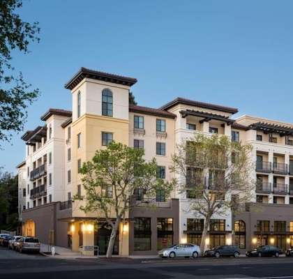 A large apartment building with a parking lot in front.