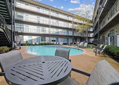 a swimming pool in a courtyard with a table and chairs