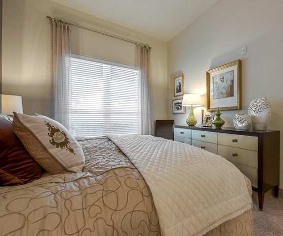 A bedroom with a queen-size bed, closet, and window at Cityplace Heights. 