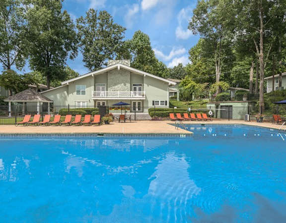 a large swimming pool with a house in the background