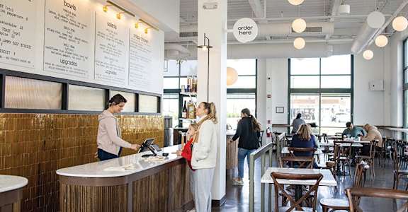people ordering at the counter of a restaurant