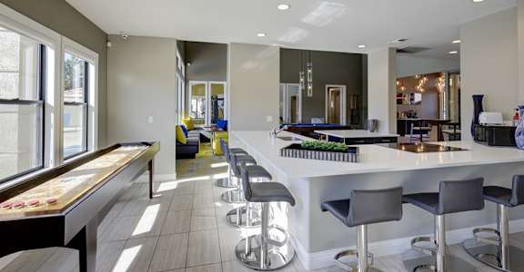 A modern kitchen with a bar area and a pool table.