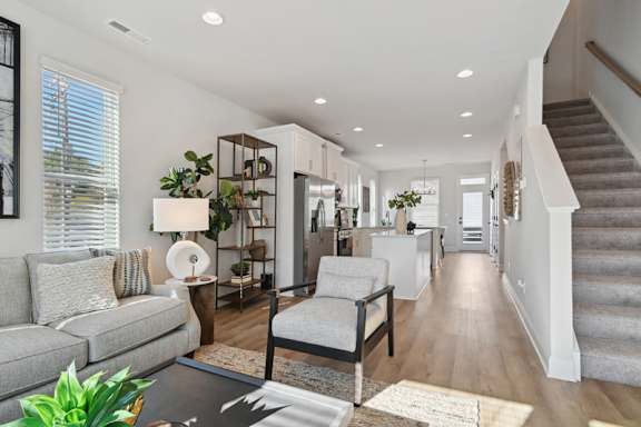 A well-lit, modern living room with a grey sofa and a wooden coffee table.