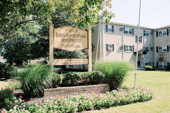 A large apartment building with a flag on the front lawn.