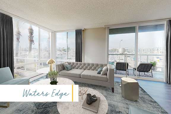 A living room with a couch, a table, and a view of the outside. at Marina Harbor, Marina del Rey, 90292
