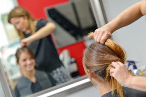 a woman getting her hair styled at a salon