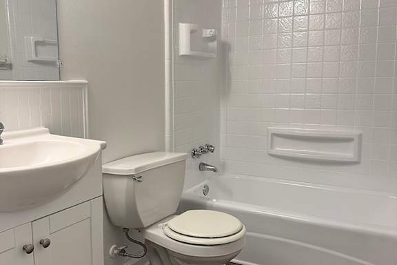 A white toilet is next to a white sink in a bathroom.