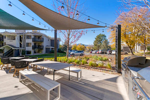 a patio with tables and chairs and a grill