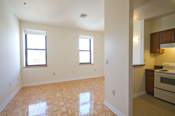 living room and partial kitchen view with hardwood floors and white walls