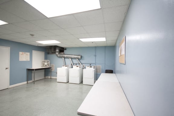 Laundry room with washer units and folding tables