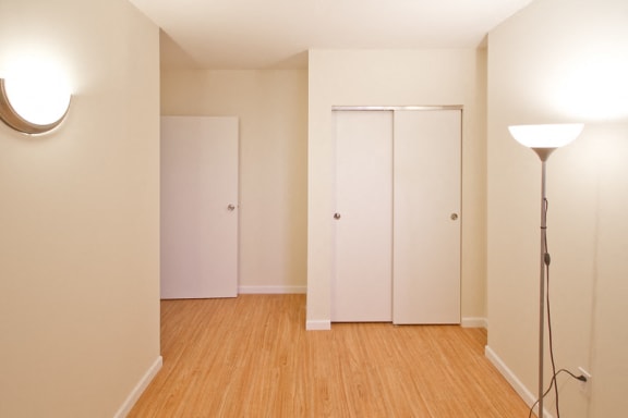 Bedroom with sliding door closets and wall lamps