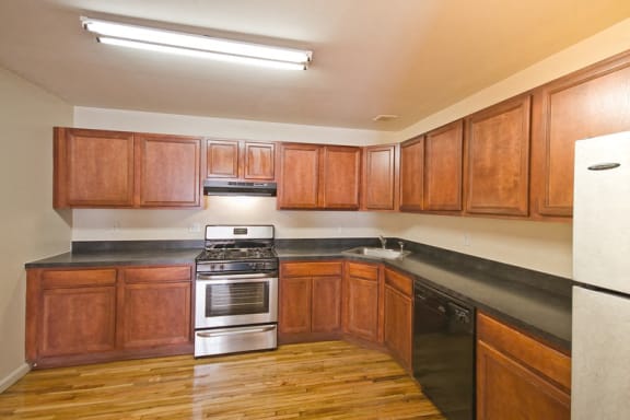 Kitchen with stainless steel appliances, hardwood floors and wooden cabinets