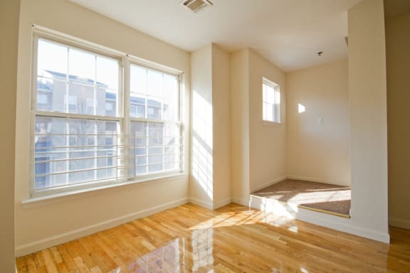 Living room with hardwood floors and alcove in corner of the room