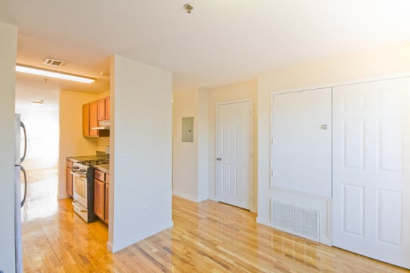 Living room with coat closet and view into kitchen area