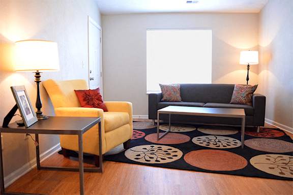 Living room with couch, chair, coffee table, sides tables, and two standing lamps