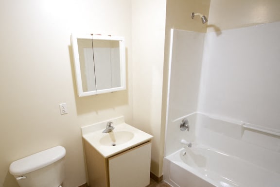 bathroom with white cabinets and walls