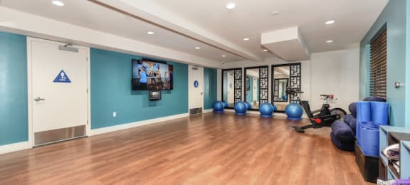 Sunnyvale Apartments for Rent - Large Fitness Center with Wood Flooring, Yoga Balls, a Spin Bike, TV, and Bathrooms