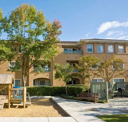 an outdoor playground in front of an apartment building