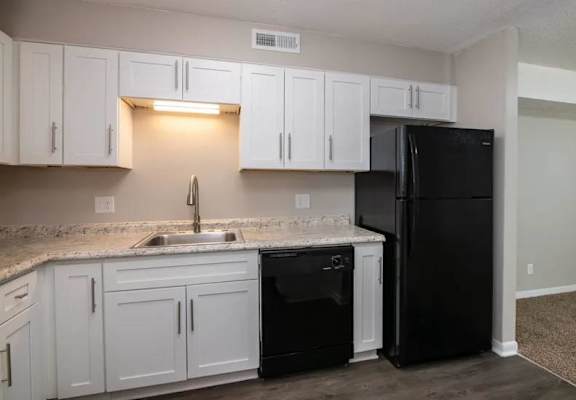 a kitchen with white cabinets and black appliances at Cleo Apartments, Athens