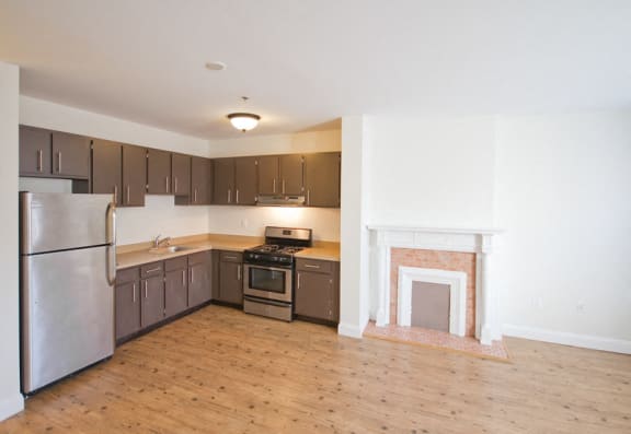 Kitchen with stainless steel appliances and living room with hardwood floors