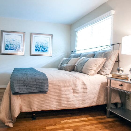 a bedroom with a bed and two pictures on the wall at Parkside at Five Points Apartments, North Carolina