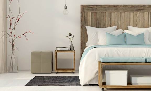 A bedroom with a large bed and a wooden headboard.