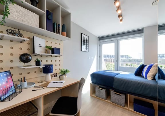 a bedroom with a bed and desk in a 555 waverly unit