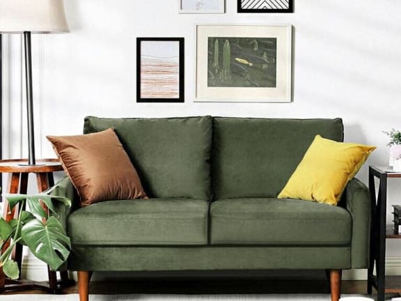 a green couch with yellow and brown pillows in a living room