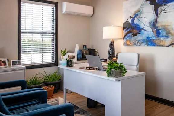 A room with a desk, chair, and a painting on the wall. at Cleo Apartments, Athens, 35611