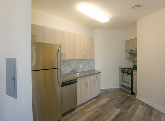 Kitchen area with stainless steel appliances like refrigerator, dishwasher and oven/stove