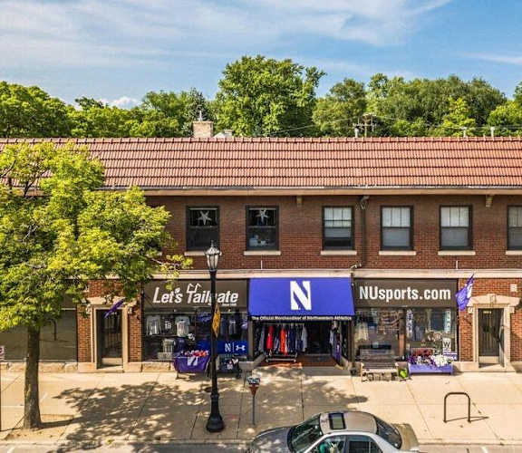 A storefront with a blue sign that says "Let's tailgate" and "NU Sports.com".