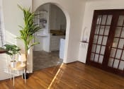 Thumbnail 2 of 6 - a living room with a wooden floor and a door