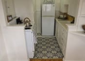 Thumbnail 5 of 6 - a small kitchen with a refrigerator and a stove